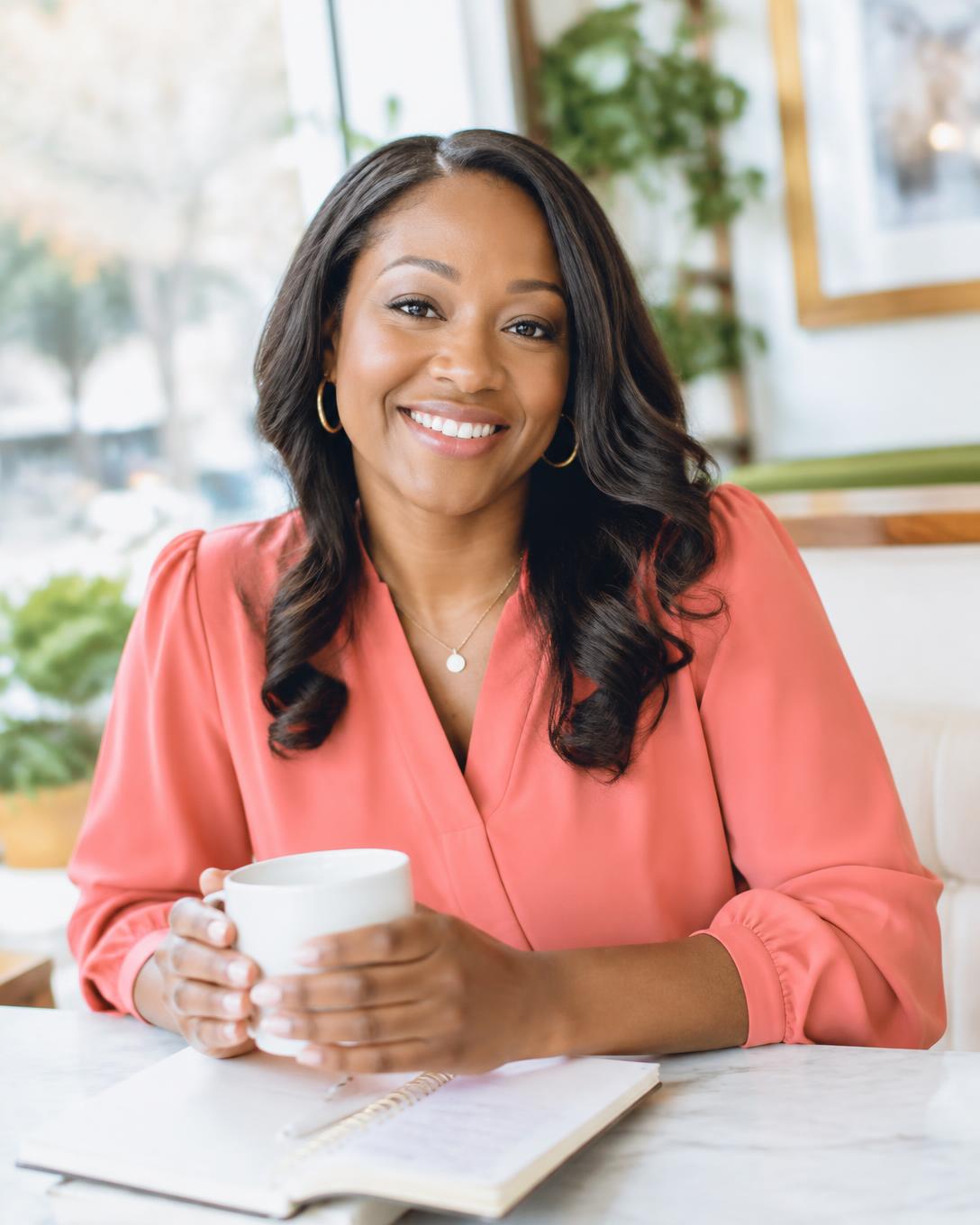 Dr. Sheraine Gilliam smiling with a cup of coffee